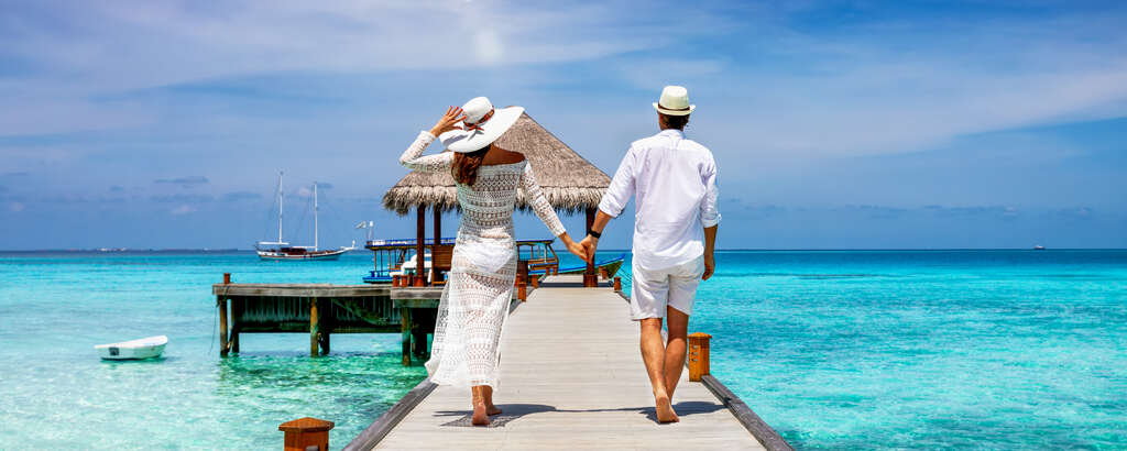 couple holding hands and walking on dock