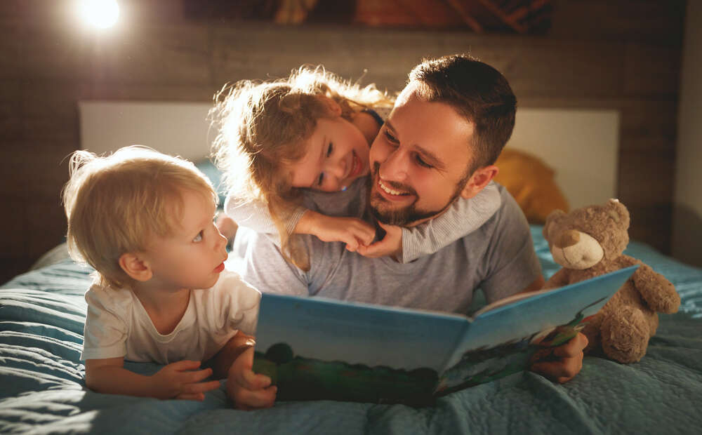 Father reading a bed time story to 2 kids